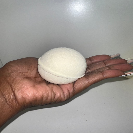 White hair detox bomb held in a hand against a plain background